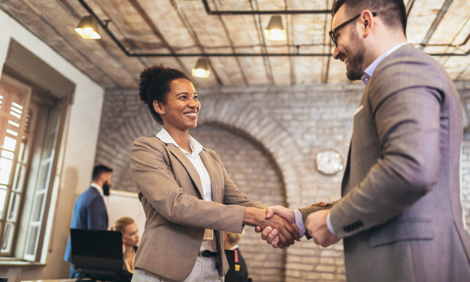 Due professionisti si stringono la mano in ufficio dopo un accordo